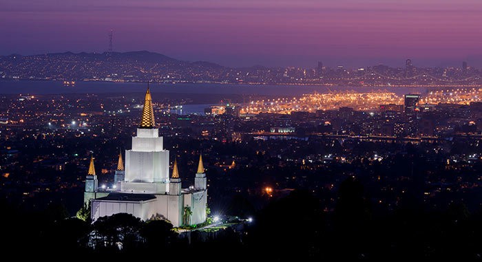 Night photo of the Mormon temple in Oakland, California at night, overlooking the city.